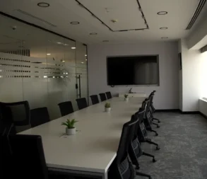 Spacious conference room with large screen and modern furniture in Riyadh.
