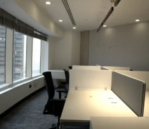 Contemporary office with workstations and large windows overlooking Riyadh.