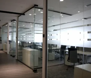 Contemporary glass-walled office with desks and chairs in Riyadh.