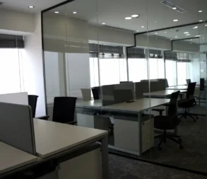 Contemporary office with glass walls and meeting tables in Riyadh.