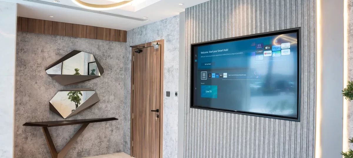 Stylish lounge space at WTC Riyadh with decorative walls, modern lighting, and smart TV.