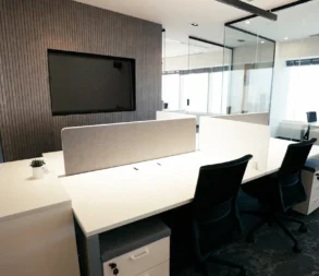 Contemporary office with desks, chairs, and a large screen in Riyadh.